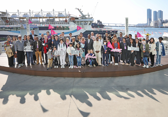 Members of the diplomatic corps representing some 40 countries pose at the sea next to the Jagalchi Seafood Market in Busan on Saturday. [PARK SANG-MOON]