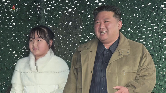 North Korean leader Kim Jong-un, right, and his daughter watch the launch of a new Hwasong-17 intercontinental ballistic missile (ICBM) at Pyongyang International Airport Friday in an image released by the North Korean Central Television Sunday. [YONHAP]