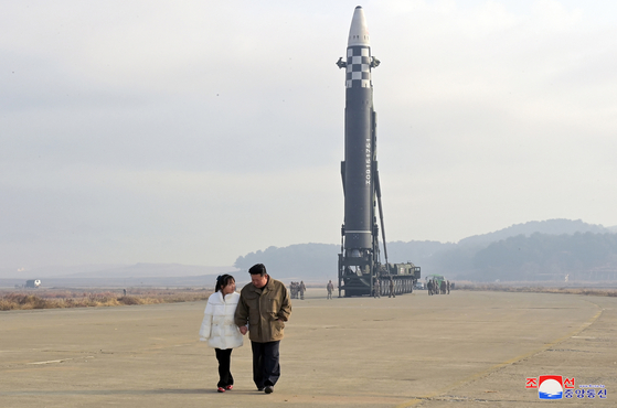 North Korean leader Kim Jong-un, right, holds hands with his daughter as they prepare to watch the launch of a new Hwasong-17 intercontinental ballistic missile (ICBM) at Pyongyang International Airport Friday in a photo released by the North's official Korean Central News Agency (KCNA) Saturday. It is the first time one of Kim’s children has been revealed to the public. [KCNA]