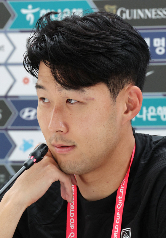 Son Heung-min speaks at a press conference after a training session for the FIFA World Cup at Al Egla Training Facility in Doha on Wednesday. The scar from his recent surgery is clearly visible by his left eye. [NEWS1]