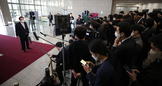President Yoon Suk-yeol, left, answers reporters' questions in a doorstepping session on Friday at the presidential office in Yongsan, central Seoul. The presidential office indefinitely suspended the doorstepping sessions starting Monday. [NEWS1]