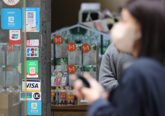 A street shop in Myeong-dong, a popular tourist destination in Jung District, central Seoul, is seen with instructions for making QR payments on its walls on Monday. As foreign tourists from Asean countries flock to Korea, many are requesting payments using QR codes instead of credit cards. The expansion of QR payment infrastructure is emerging as a hot topic amid the sharp drop in the value of the won. [YONHAP]