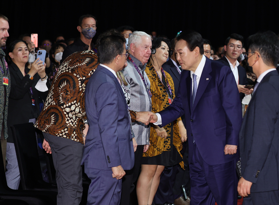 President Yoon Suk-yeol, right, greets people after giving a speech at the B20 summit at the Bali Nusa Dua Convention Center in Indonesia on Monday. [YONHAP]
