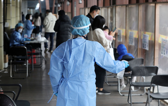 A health worker sprays disinfectants at a Covid-19 testing center in Songpa District, western Seoul, on Tuesday. [NEWS1]