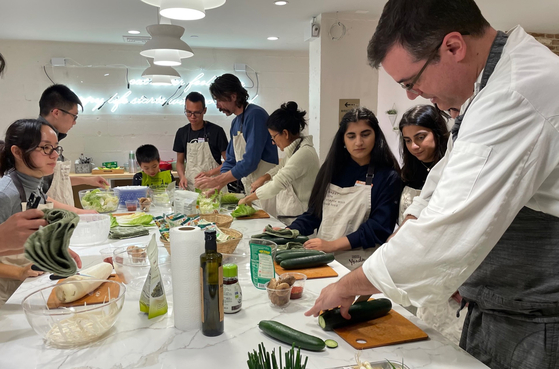 Foreigners take a kimchi making class at the Yondu Culinary Studio in New York, using Sempio’s kimchi making kit. [SEMPIO]