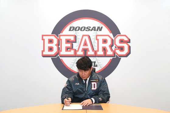 Yang Eui-ji poses while signing a new contract with the Doosan Bears in a photo released by the club on Tuesday.  [DOOSAN BEARS]