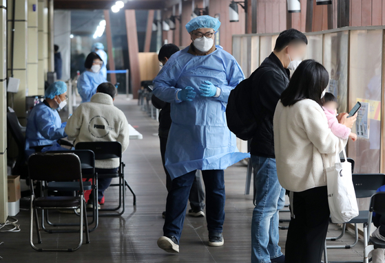 A health worker walks through a Covid-19 testing center in Songpa District, southern Seoul, on Tuesday. [NEWS1]
