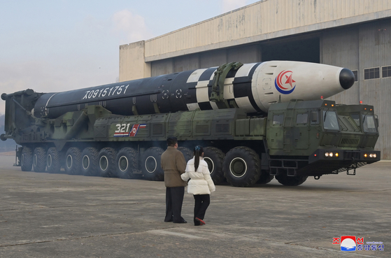 North Korean leader Kim Jong-un, left, alongside his daughter wearing a winter jacket, views a new type of the Hwasong-17 intercontinental ballistic missile (ICBM) during an on-site inspection of the missile launch at Pyongyang International Airport on Nov. 18, 2022,.[YONHAP]