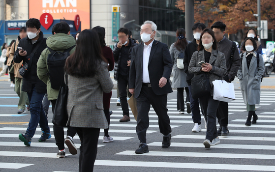 People commuting to work walk across a street in Jongno District, central Seoul, on Nov. 17, 2022. [NEWS1]
