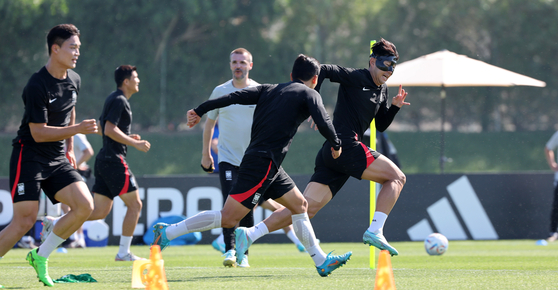 Son Heung-min, right, warms up with the Korean national team during a training session at Al Egla Training Site in Doha, Qatar on Wednesday. Korea will play its first match against Uruguay on Thursday. [AP/YONHAP] 