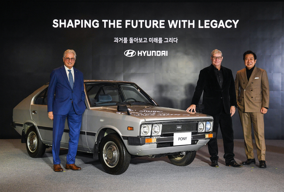 Italian car designer Giorgetto Giugiaro, left, poses with Hyundai Motor's Pony, along with Luc Donckerwolke, chief creative officer of Hyundai Motor, and Lee Sang-yup, executive vice president and head of Hyundai Motor’s Global Design Center, at a press event Thursday in Yongin, Gyeonggi. [HYUNDAI MOTOR] 