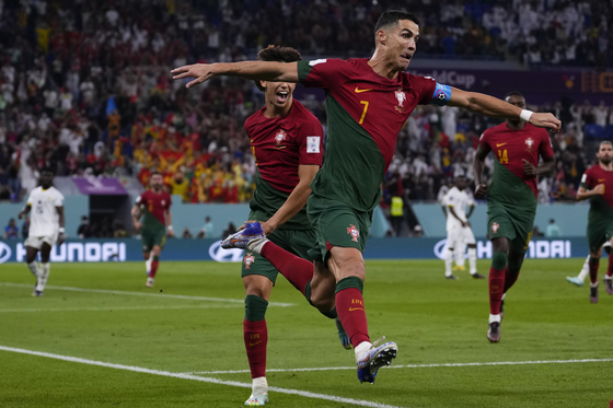 Portugal's Cristiano Ronaldo celebrates after scoring from the penalty spot during a World Cup Group H match against Ghana at Stadium 974 in Doha, Qatar on Thursday. Ronaldo, scoring in his fifth World Cup, put Portugal ahead in the 65th minute. Four more goals followed over the final half an hour to end the game with Portugal up 3-2.  [AP/YONHAP]
