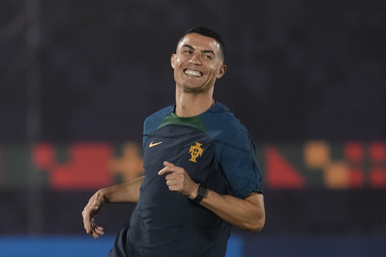 Portugal's Cristiano Ronaldo smiles as he warms up during the Portugal's official training on the eve of the group H World Cup soccer match between Portugal and Ghana at the Al Shahaniya SC training site in Al Shahaniya, Qatar on Wednesday. [AP/YONHAP]