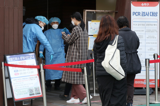 People wait in line to get tested for Covid-19 at a center in Songpa District, southern Seoul, on Wednesday morning. [NEWS1] 