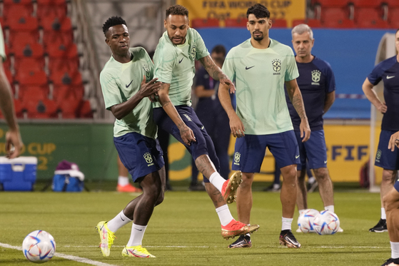 Brazil's Neymar, center, Vinicius Junior, left, and Lucas Paqueta practice during a training session at the Grand Hamad stadium, in Doha, Qatar on Wednesday. Brazil will play their first match in the World Cup against Serbia on Thursday. [AP/YONHAP]