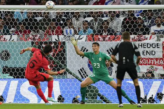 Hwang Ui-jo, left, misses a chance to score during a World Cup Group H match against Uruguay at Education City Stadium in Qatar on Thursday.  [AP/YONHAP]