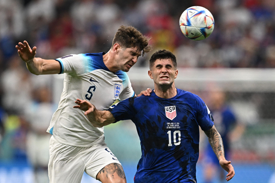 England's defender John Stones, left and United States' forward Christian Pulisic fight for the ball during the Qatar 2022 World Cup Group B football match between England and USA at the Al-Bayt Stadium in Al Khor, Doha on Saturday. England was held to a 0-0 draw and missed the chance to secure their spot in the knockout round on Saturday. [AFP/YONHAP]