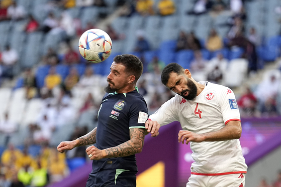 Australia's Jamie Maclaren and Tunisia's Yassine Meriah go for a header during the World Cup group D football match between Tunisia and Australia at the Al Janoub Stadium in Al Wakrah, Qatar on Saturday. Australia won their first match of the tournament, after Mitchell Duke headed in the sole goal. [AP/YONHAP]