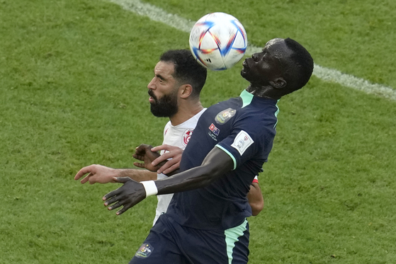 Tunisia's Yassine Meriah, left, and Australia's Awer Mabil go for the header during the World Cup group D soccer match between Tunisia and Australia at the Al Janoub Stadium in Al Wakrah, Qatar on Saturday. [AP/YONHAP]