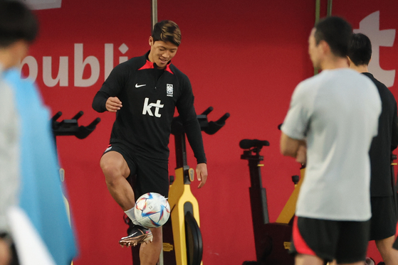 Hwang Hee-chan, left, trains on the field at Al Egla Training Site in Doha, Qatar, on Saturday. Hwang returned to the field after noticeably skipping field training before Thursday's match against Uruguay. [YONHAP]