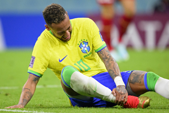 Brazil's Neymar grabs his ankle after an injury during the World Cup group G soccer match between Brazil and Serbia, at the the Lusail Stadium in Lusail, Qatar on Thursday. [AP/YONHAP]