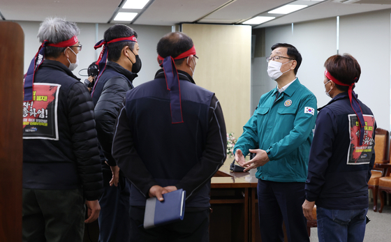 Vice Minister of Land, Infrastructure and Transport Eo Myeong-so, second from right, speaks with members of Cargo Truckers Solidarity before the negotiations start at the government complex in Sejong on Monday. [YONHAP]