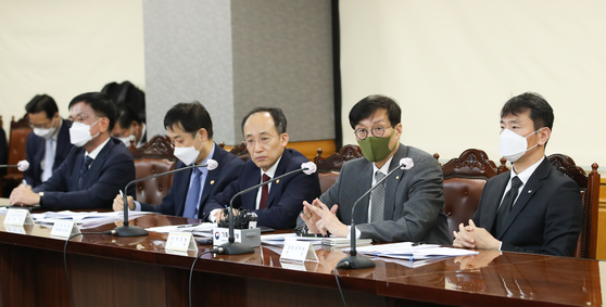 Finance Minister Choo Kyung-ho, center, and Bank of Korea Gov. Rhee Chang-yong, second from right, in a meeting held in central Seoul on Monday to discuss measures on stabilizing the financial market. [YONHAP] 