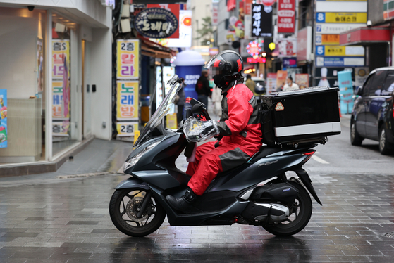A delivery worker is on the move on Monday in downtown Seoul before the Korean national football team plays its match against Ghana. Streets and pubs are expected to be filled with people cheering, and delivery workers kept busy with households ordering food to cheer at home. [YONHAP]