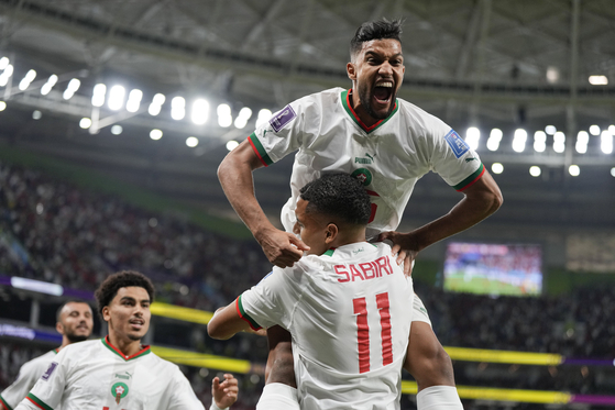 Morocco's Yahya Jabrane, top, celebrates with Abdelhamid Sabiri after Sabiri scored a goal during the World Cup Group F match between Belgium and Morocco, at the Al Thumama Stadium in Doha, Qatar on Sunday. [AP/YONHAP]