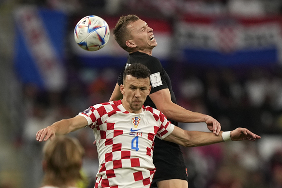 Canada's Alistair Johnston, right, and Croatia's Ivan Perisic challenge for the ball during the World Cup Group F match between Croatia and Canada, at the Khalifa International Stadium in Doha, Qatar on Sunday. [AP/YONHAP]