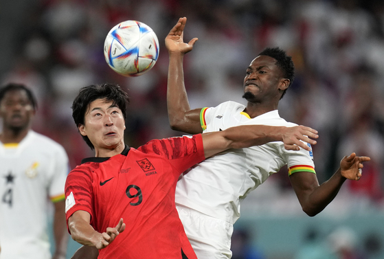 Cho Gue-sung, left, duels for the ball with Ghana's Abdul Rahman Baba during the World Cup group H football match between Korea and Ghana, at the Education City Stadium in Al Rayyan, Qatar on Monday. [AP/YONHAP]