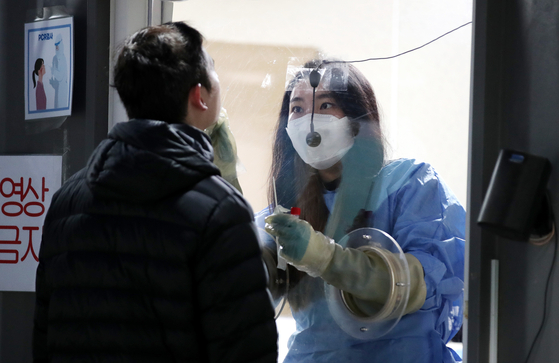 A man gets tested for Covid-19 at a testing center in Yongsan District, central Seoul, on Tuesday morning. [NEWS1]