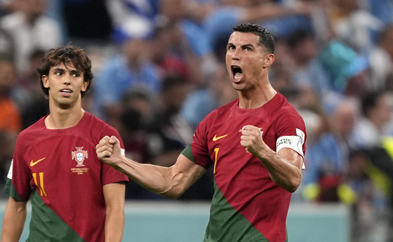 Portugal's Cristiano Ronaldo, right, celebrates his team's opening goal beside Portugal's Joao Felix, during the World Cup Group H football match between Portugal and Uruguay, at the Lusail Stadium in Lusail, Qatar on Monday. [AP/YONHAP]