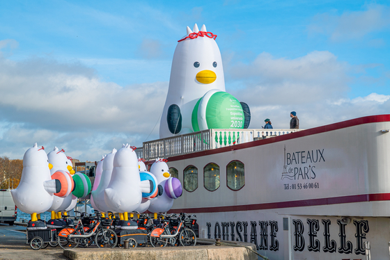Boogi the seagull, Busan Expo 2030 mascot, sits on a Seine River cruise boat in Paris on Tuesday as the Bureau International des Expositions (BIE) holds its General Assembly in Paris from Nov. 28 to 29. The eight-meter (26-feet)-tall mascot wears glasses, has 'EXPO' glasses on its head and holds a macaroon to promote its bid to host the World Expo. [YONHAP] 