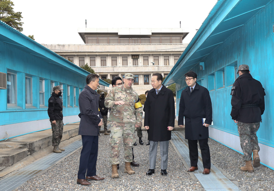 Unification Minister Kwon Young-se, center, listens to U.S. Air Force Lt. Col. Griff Hofman of the Military Armistice Commission, second from right, and Korean interpreter Shin Tong-ho, far right, as he tours the inter-Korean truce village of Panmunjom on Tuesday. [JOINT PRESS CORPS]