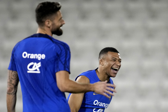 France's Kylian Mbappe, right, jokes with Olivier Giroud during a training session at the Jassim Bin Hamad stadium in Doha, Qatar, on Monday. [AP/YONHAP]