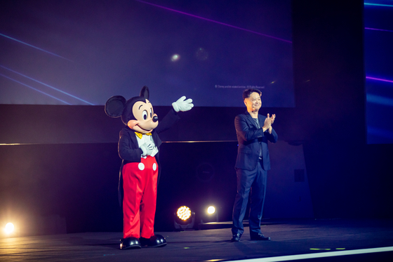 Luke Kang, president of The Walt Disney Company Asia Pacific, with Mickey Mouse at the opening ceremony of the Disney Content Showcase in Singapore. [THE WALT DISNEY COMPANY]