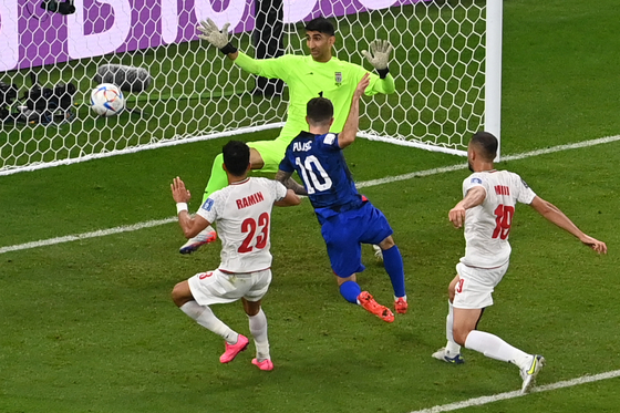United States' forward Christian Pulisic, center, scores his team's first goal past Iran's goalkeeper Alireza Beiranvand during the Qatar 2022 World Cup Group B football match between Iran and the United States at the Al-Thumama Stadium in Doha on Tuesday. [AFP/YONHAP]