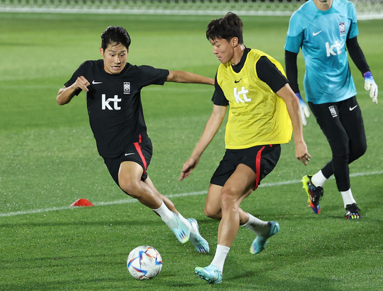 Lee Kang-in, left, and Hwang Ui-jo train on Wednesday at Al Egla Training Site in Doha, Qatar ahead of Korea's final group stage match against Portugal scheduled to take place on Friday. [YONHAP]