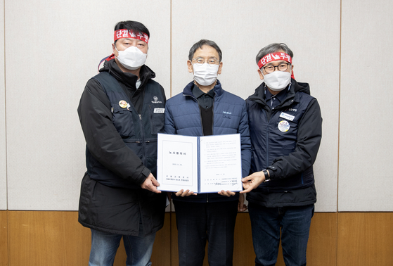 Seoul Metro CEO Kim Sang-bum, center, holds a written agreement between labor and management with representatives from Seoul Metro's labor unions. Unionized workers at Seoul Metro reached an agreement with the management on Thursday. [NEWS1]