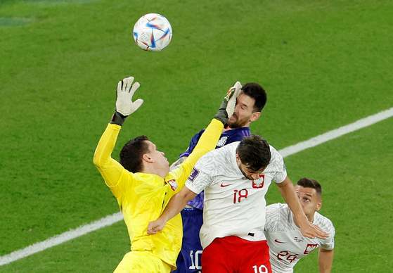 Poland's Wojciech Szczesny fouls Argentina's Lionel Messi resulting in a penalty being awarded to Argentina during the Qatar 2022 World Cup Group C football match between Poland and Argentina at Stadium 974 in Doha on Wednesday. [REUTERS/YONHAP]
