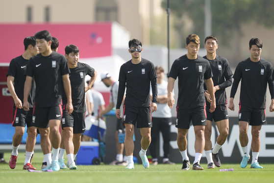 Son Heung-min, center, walks on the pitch with teammates upon their arrival for the Korea's official training on the eve of the group H World Cup football match between Korea and Portugal, at the Al Egla Training Site 5 in Doha, Qatar on Thursday. [AP/YONHAP]