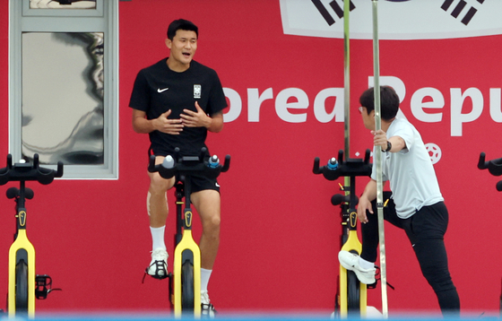 Kim Min-jae trains on a bike on the sidelines of a national team training session at Al Egla Training Site in Doha, Qatar, on Thursday. Kim has been dealing with discomfort in his calf since Korea's first match against Uruguay on Nov. 24. [YONHAP]