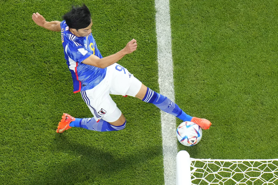 Japan's Kaoru Mitoma appears to have the ball over the line before crossing it for a goal during the World Cup group E soccer match between Japan and Spain, at the Khalifa International Stadium in Doha, Qatar, Thursday. [AP/YONHAP]