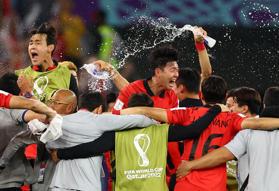 Son Heung-min celebrates with his teammates and coaching staff celebrate after beating Portugal 2-1 and qualifying for the knockout stages of the 2022 World Cup on Friday evening at the Education City Stadium in Al-Rayyan, west of Doha. [REUTERS/YONHAP] 