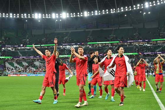 The Taeguk Warriors celebrate after beating Portugal 2-1 and qualifying for the knockout stages on Friday evening at the Education City Stadium in Al-Rayyan, west of Doha. [AFP/YONHAP]