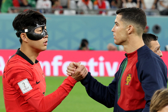 Son Heung-min, left, greets Cristiano Ronaldo ahead of Korea's last group stage match against Portugal on Friday evening at the Education City Stadium in Al-Rayyan, west of Doha. Korea later beat Portugal 2-1 and advanced to the round of 16. [NEWS1]