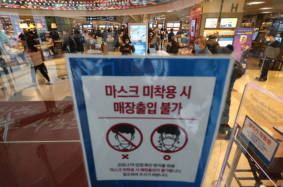 A notice posted at an entrance of a bookstore in Seoul on Sunday informing customers that face masks are required to enter [YONHAP]