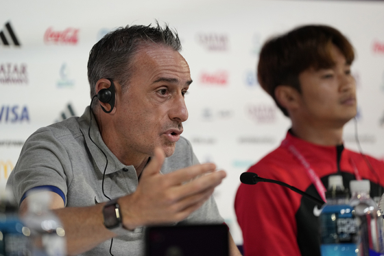 Korea's head coach Paulo Bento, left, answers questions next to Korean defender Kim Jin-su during a press conference at the Qatar National Convention Center on the eve of the World Cup round of 16 match between Brazil and Korea in Doha, Qatar on Sunday. [AP/YONHAP]