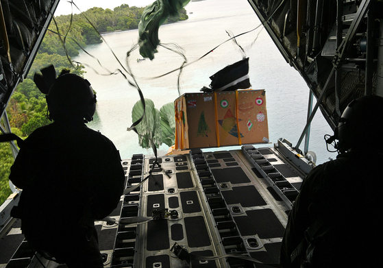 South Korean Air Force personnel airdrop a parcel with humanitarian supplies to islanders in Micronesia in the Pacific Ocean on Sunday as a part of the U.S.-led Operation Christmas Drop. [AIR FORCE]